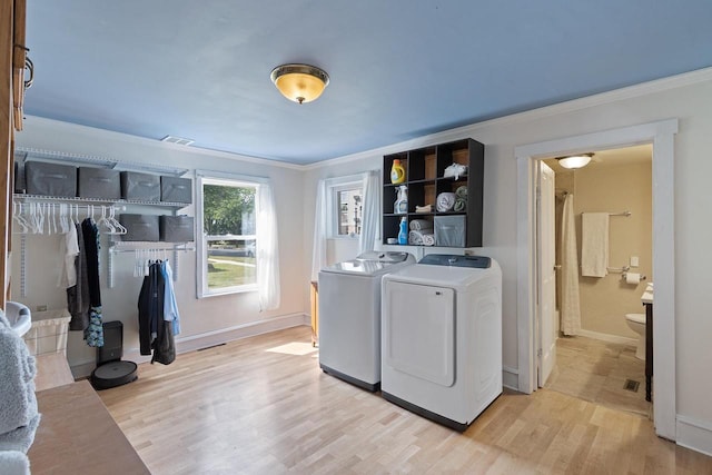 washroom featuring laundry area, crown molding, and light wood-style flooring