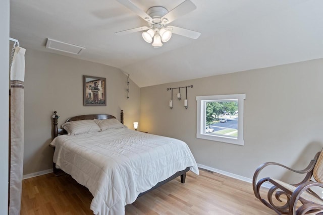 bedroom with light wood finished floors, attic access, baseboards, and vaulted ceiling