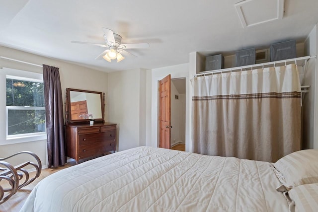 bedroom with attic access and a ceiling fan