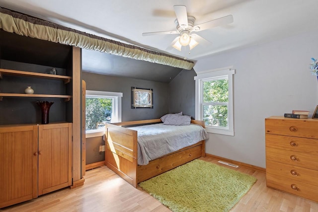 bedroom with ceiling fan, visible vents, baseboards, vaulted ceiling, and light wood-type flooring