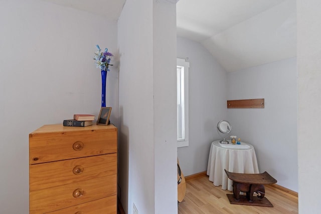 bedroom featuring light wood-type flooring, baseboards, and vaulted ceiling