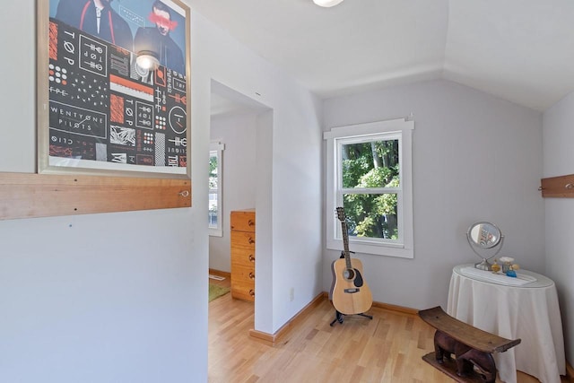 interior space with lofted ceiling, light wood-style flooring, and baseboards