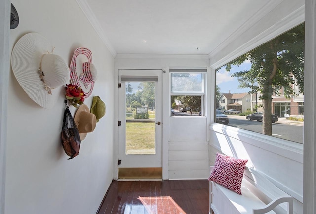 doorway to outside featuring ornamental molding, a sunroom, dark wood-type flooring, and baseboards