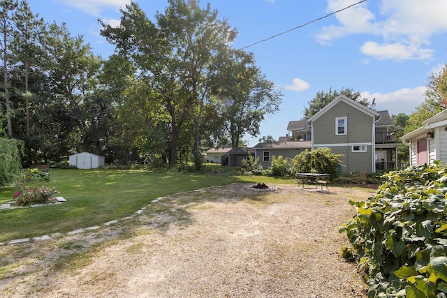 view of yard with an outbuilding, a fire pit, and a shed