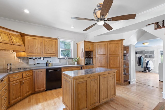 kitchen with crown molding, a kitchen island, backsplash, and black appliances