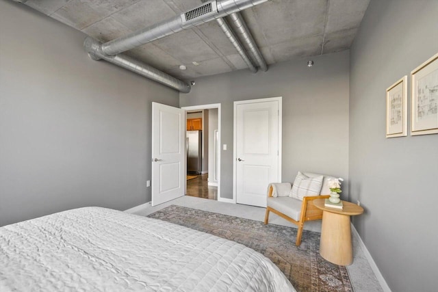 bedroom with freestanding refrigerator, visible vents, baseboards, and dark colored carpet