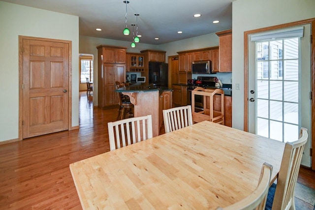 dining room featuring baseboards, wood finished floors, and recessed lighting