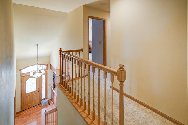 entryway with light wood-style floors, baseboards, and a chandelier