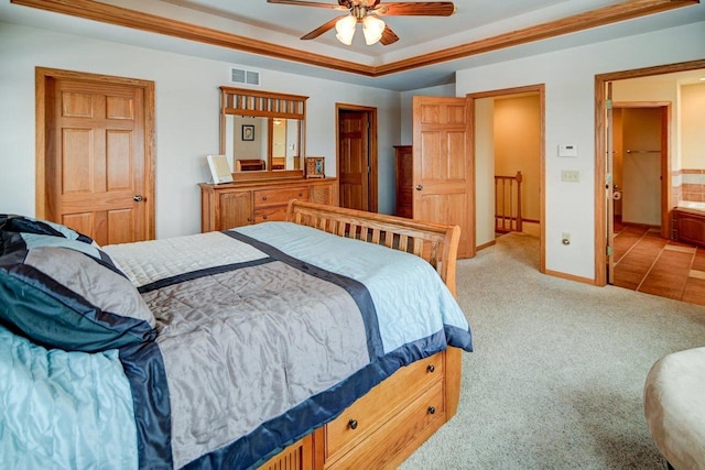 bedroom with connected bathroom, light colored carpet, visible vents, baseboards, and a raised ceiling