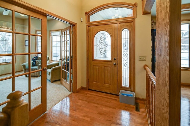 entrance foyer with light wood-style flooring, baseboards, and french doors