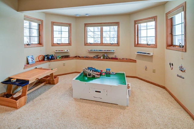 recreation room featuring baseboards and a healthy amount of sunlight