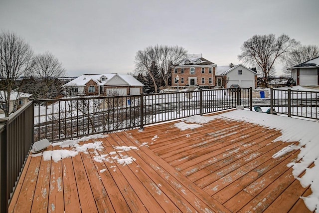 snow covered deck with a residential view