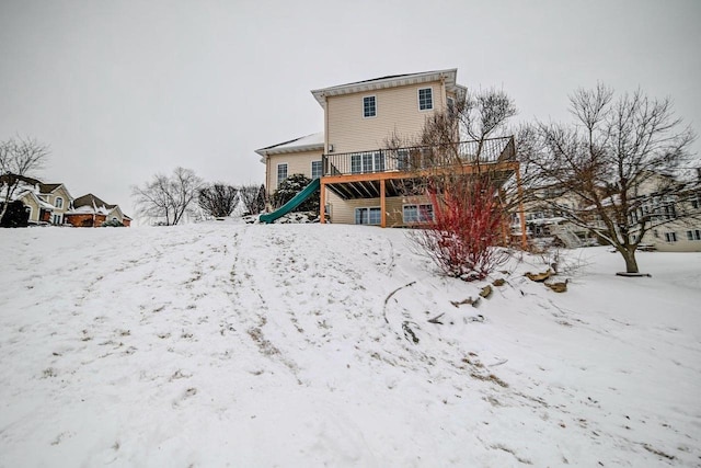 snow covered house featuring a wooden deck