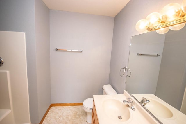 bathroom featuring toilet, baseboards, and vanity