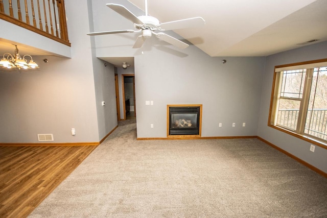 unfurnished living room with a glass covered fireplace, visible vents, and baseboards