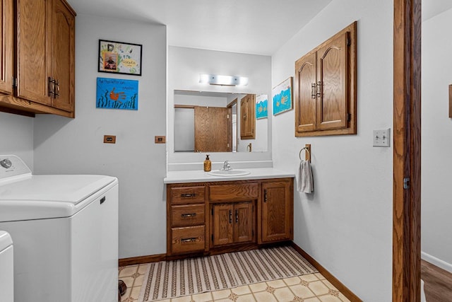 bathroom with toilet, vanity, baseboards, tile patterned floors, and washer / clothes dryer