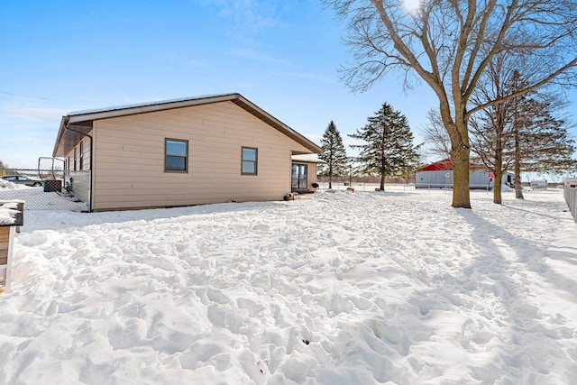 view of snow covered exterior featuring fence