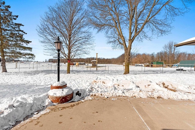 snowy yard featuring fence