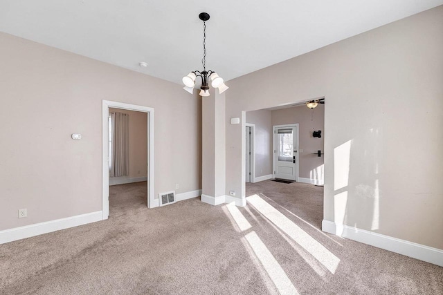 unfurnished dining area featuring carpet floors, baseboards, visible vents, and a notable chandelier