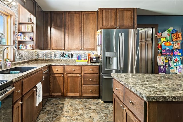 kitchen featuring light stone counters, open shelves, tasteful backsplash, a sink, and stainless steel fridge with ice dispenser