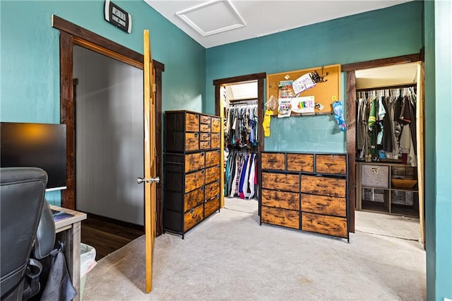 carpeted bedroom with attic access and a spacious closet