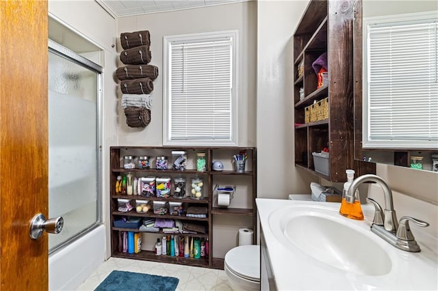 full bath featuring enclosed tub / shower combo, vanity, and toilet