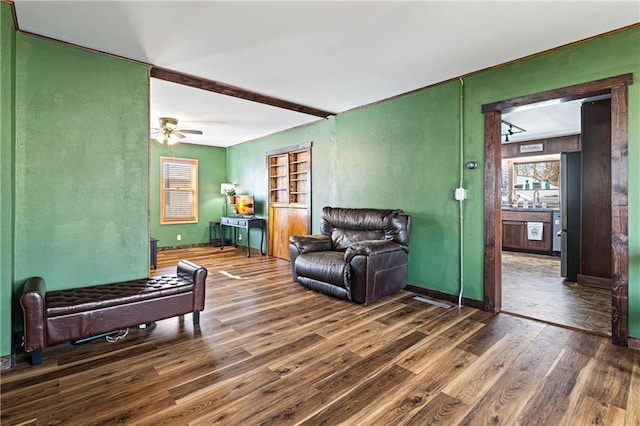 living room featuring ceiling fan, dark wood-style flooring, and baseboards