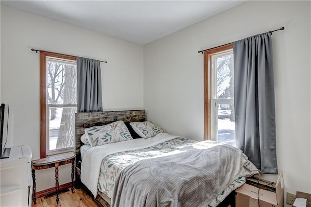 bedroom featuring multiple windows and light wood-style floors