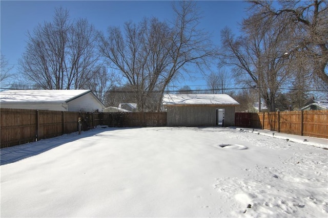 yard layered in snow with a fenced backyard