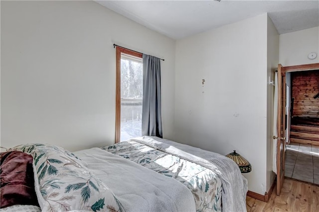 bedroom with light wood-type flooring and baseboards