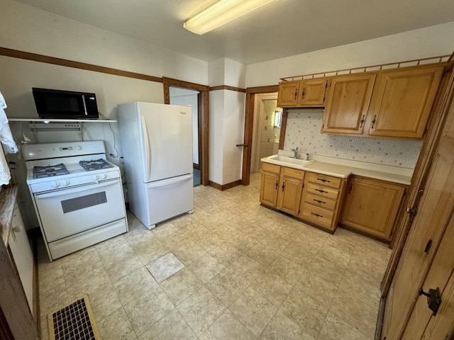 kitchen with white appliances, visible vents, brown cabinets, light countertops, and a sink