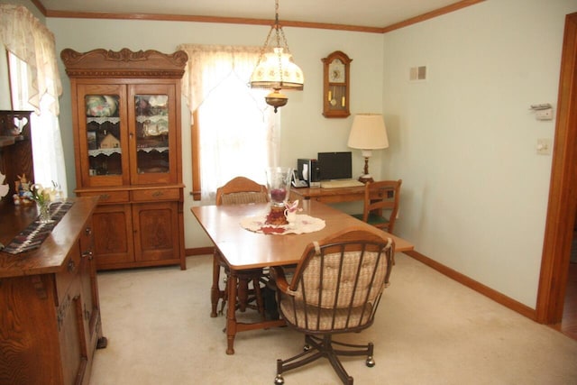 dining room featuring baseboards, light carpet, and crown molding