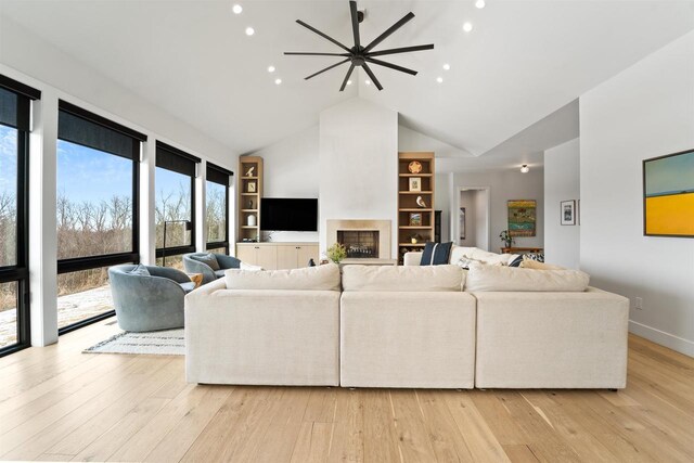 W4038 Maplewood Ln, Fond Du Lac, WI 54937 - living room featuring baseboards, built in features, a fireplace, light wood-style floors, and high vaulted ceiling