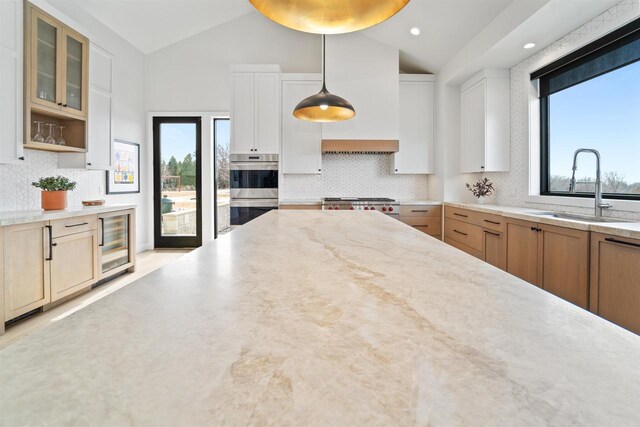 W4038 Maplewood Ln, Fond Du Lac, WI 54937 - kitchen with lofted ceiling, a sink, stainless steel double oven, wine cooler, and range