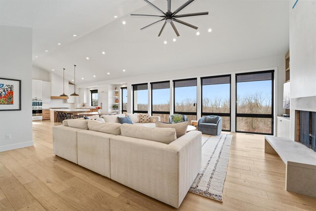 W4038 Maplewood Ln, Fond Du Lac, WI 54937 - living area featuring baseboards, high vaulted ceiling, a premium fireplace, recessed lighting, and light wood-style floors