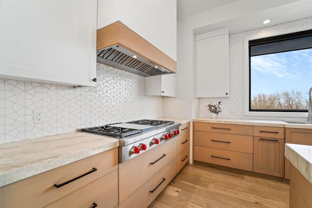 W4038 Maplewood Ln, Fond Du Lac, WI 54937 - kitchen featuring premium range hood, light wood-type flooring, a sink, decorative backsplash, and stainless steel gas cooktop