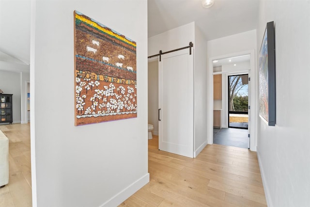 W4038 Maplewood Ln, Fond Du Lac, WI 54937 - corridor featuring a barn door, baseboards, and light wood-style flooring