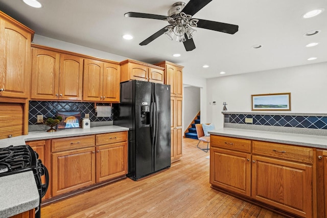 kitchen with black appliances, light wood-style flooring, light countertops, and recessed lighting