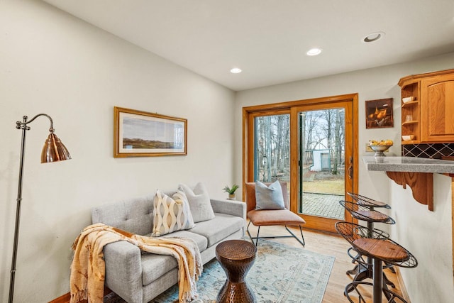 living area with light wood-type flooring and recessed lighting