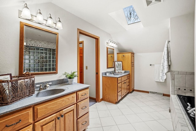 bathroom featuring lofted ceiling with skylight, two vanities, and a sink