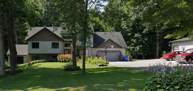 view of front facade featuring an attached garage, concrete driveway, and a front yard