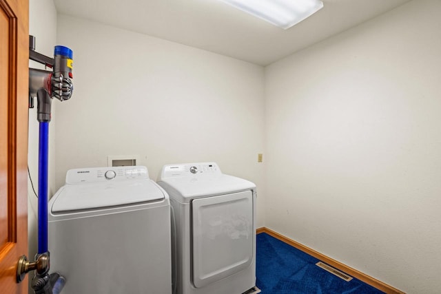 clothes washing area with laundry area, baseboards, visible vents, and independent washer and dryer