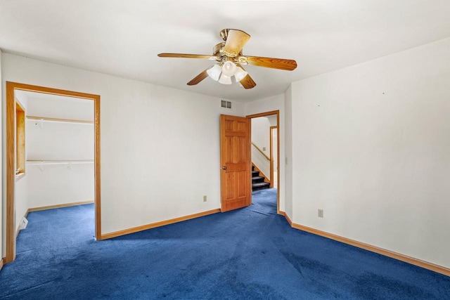 empty room featuring carpet flooring, ceiling fan, visible vents, and baseboards