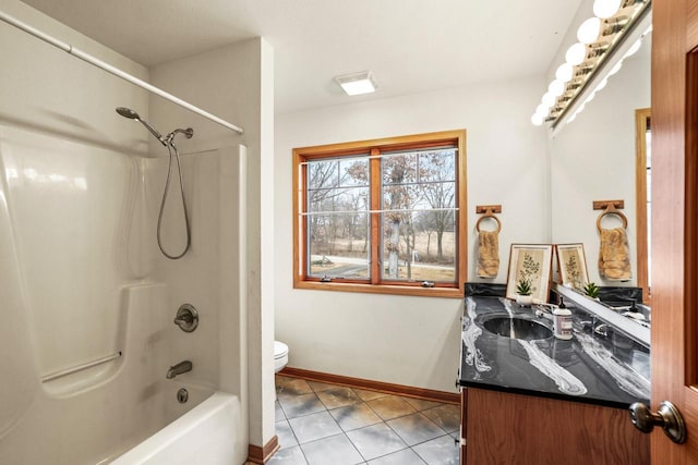 full bath featuring toilet, washtub / shower combination, vanity, baseboards, and tile patterned floors