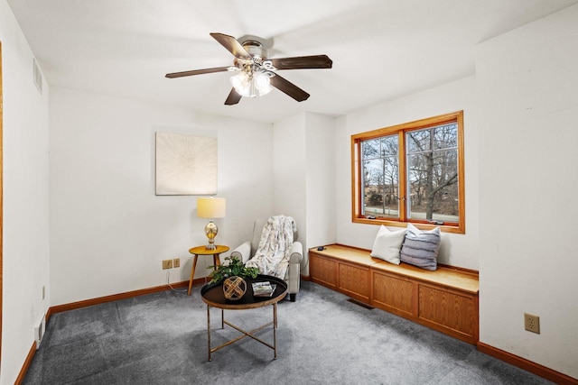 sitting room with carpet floors, a ceiling fan, visible vents, and baseboards