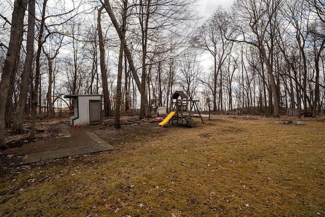 view of yard with an outbuilding, a storage shed, and a playground