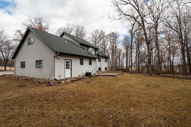 view of property exterior with a yard and roof with shingles