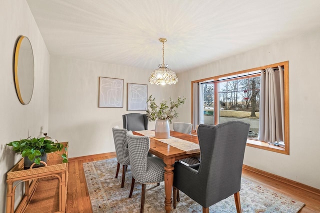 dining space featuring wood finished floors and baseboards