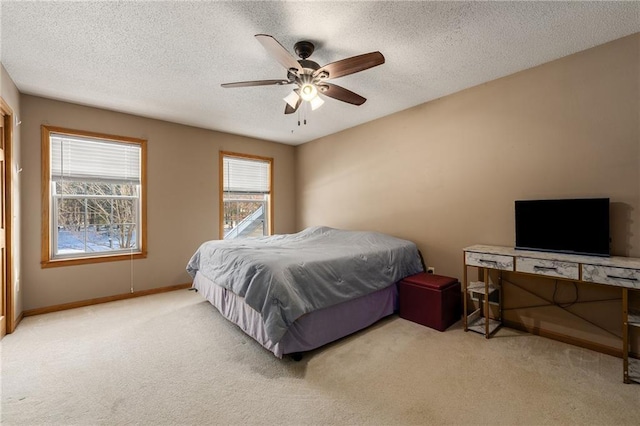 bedroom with a ceiling fan, light colored carpet, and a textured ceiling