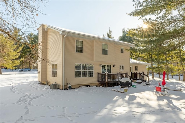 snow covered property featuring a deck and central AC